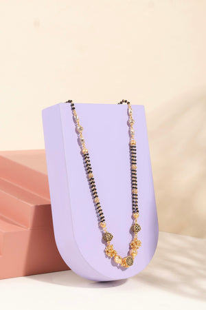 Gold and black beaded anti-tarnish mangalsutra chain on display stand